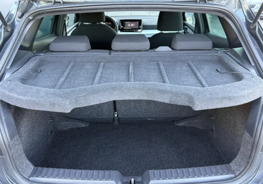Coffre ouvert d’une SEAT Ibiza gris magnétique, vue arrière montrant l’espace de chargement et l’intérieur avec écran tactile.