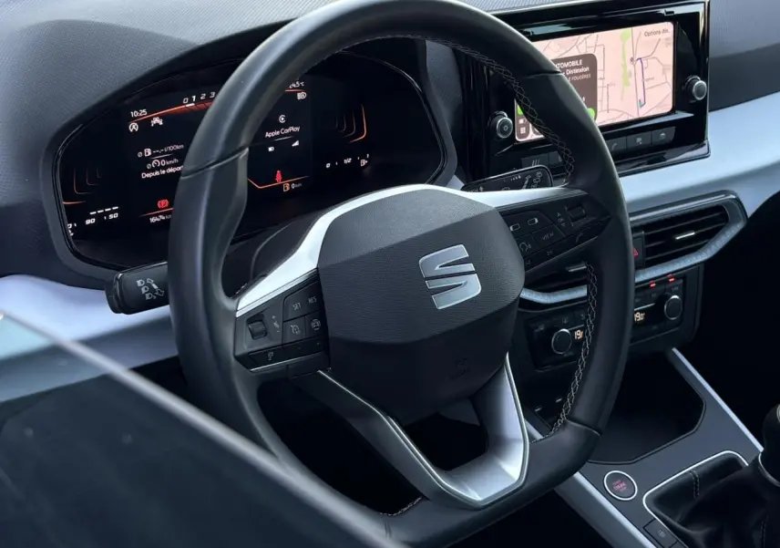 Vue intérieure centrée sur le volant cuir multifonction et le tableau de bord digital de la SEAT Ibiza TSI 115 Xcellence.