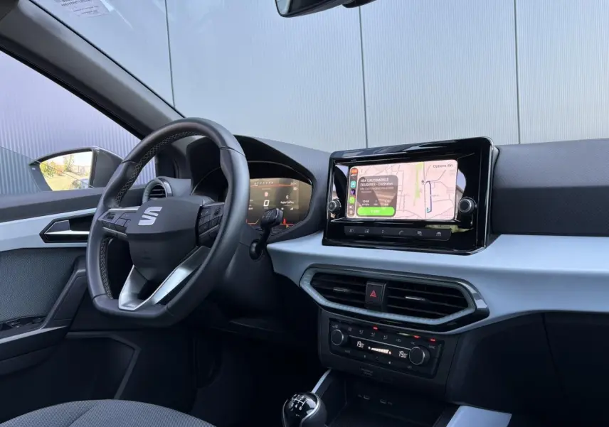 Vue intérieure côté conducteur de la SEAT Ibiza TSI 115 Xcellence 2025, volant cuir multifonction et écran tactile central.