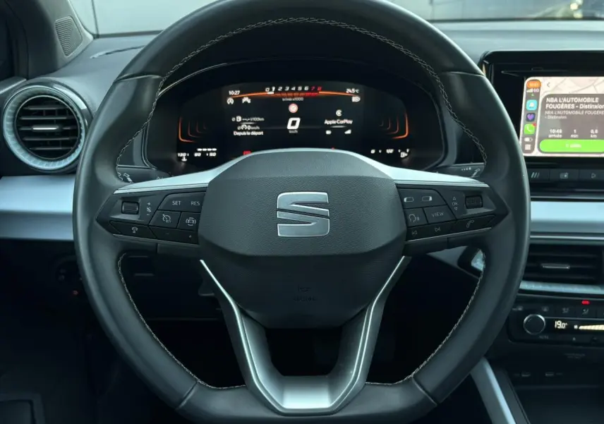 Vue rapprochée du volant cuir multifonction de la SEAT Ibiza 2025 avec tableau de bord digital et écran tactile à droite.