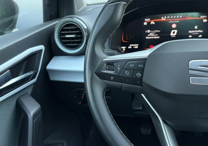 Vue rapprochée du volant cuir noir et du tableau de bord digital de la SEAT Ibiza TSI 115 Xcellence 2025 en gris Magnétique.