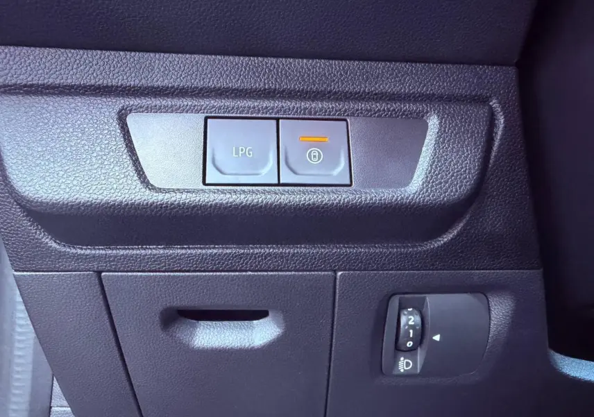 Gros plan sur les commandes intérieures noires avec bouton LPG et réglage des phares, tableau de bord Dacia Sandero 2025.
