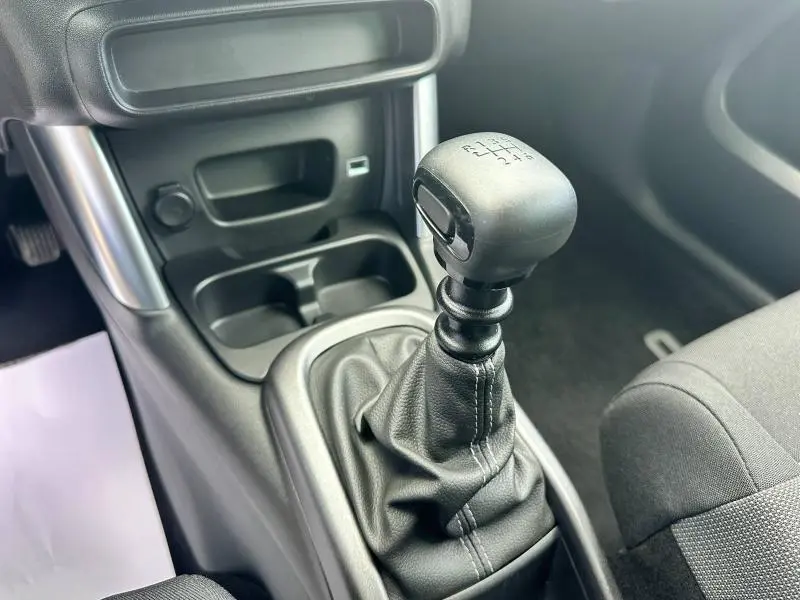 Le levier de vitesses manuel en gros plan dans l'habitacle sombre du Citroën C3 Aircross PureTech 110ch Shine 2021.