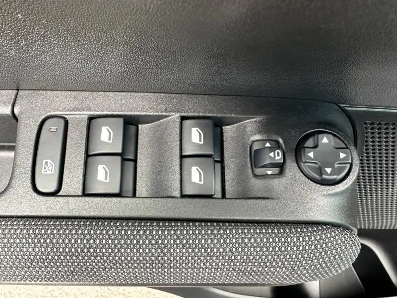 Panneau de commandes des vitres et rétroviseurs côté conducteur du Citroën C3 Aircross PureTech 2021 en tissu gris.