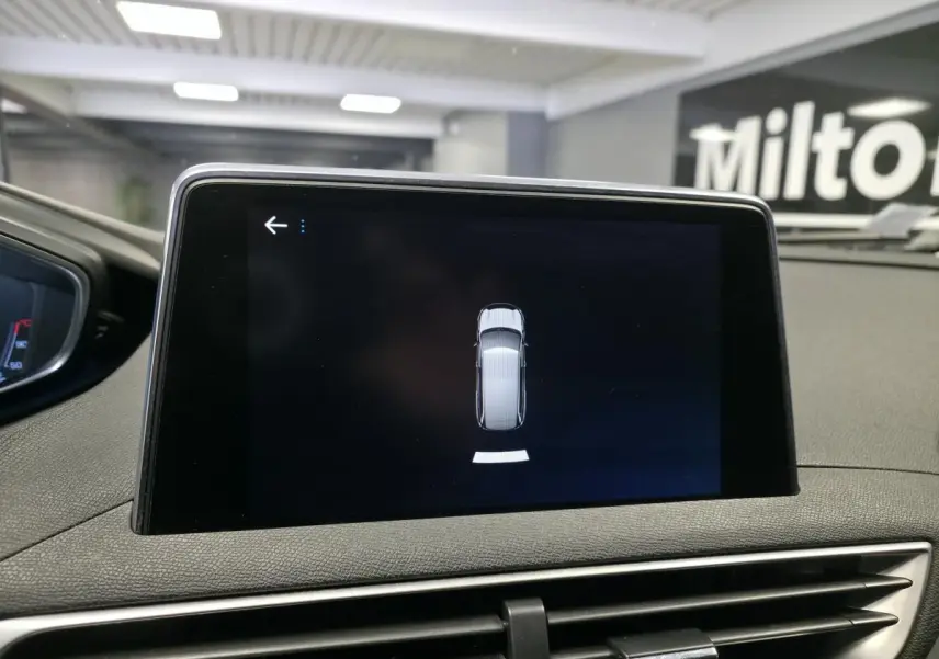 Écran tactile central affichant l'aide au stationnement du Peugeot 5008 bleu, vue intérieure du tableau de bord.