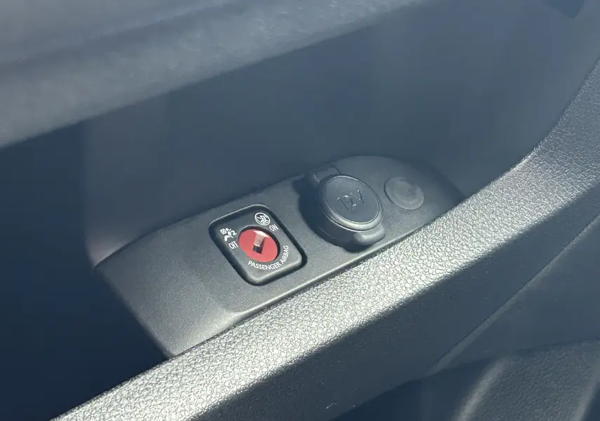 Gros plan sur le bouton de désactivation de l'airbag passager et prise 12V dans l'habitacle du Citroën Jumpy gris titane.