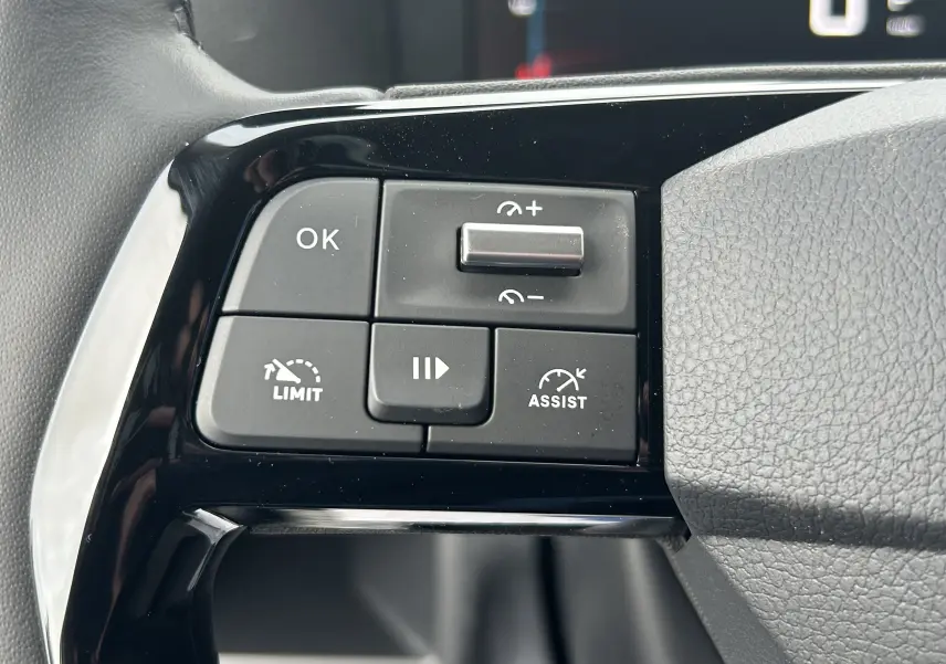 Gros plan sur les commandes de régulateur de vitesse et limiteur sur le volant d’un Citroën Jumpy gris titane.