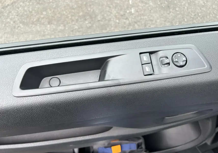 Gros plan sur la commande de lève-vitres et réglage des rétroviseurs côté conducteur du Citroën Jumpy Cabine Approfondie gris titane.