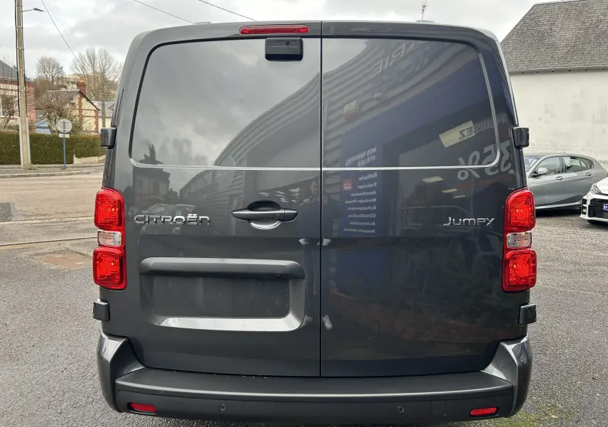 Vue arrière du Citroën Jumpy cabine approfondie gris titane métal avec portes battantes et feux rouges visibles.