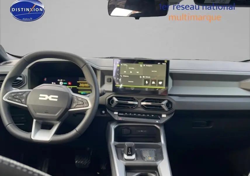 Vue intérieure avant du tableau de bord du Dacia Bigster gris schiste avec écran tactile central et volant multifonction.