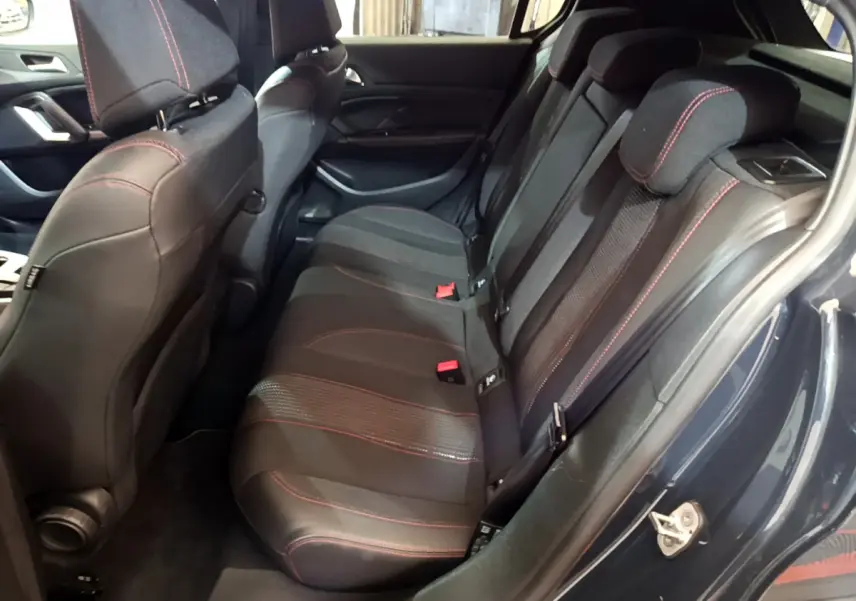Vue intérieure côté droit sur la banquette arrière noire avec surpiqûres rouges de la Peugeot 308 gris foncé 2016.