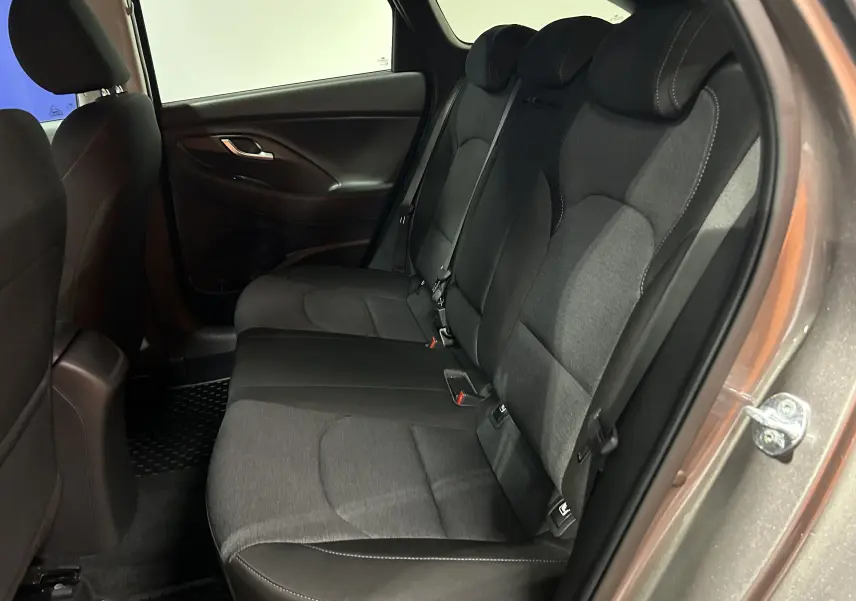 Vue intérieure côté droit des sièges arrière en tissu gris foncé du Hyundai i30 SW 2022 couleur bronze métallique.