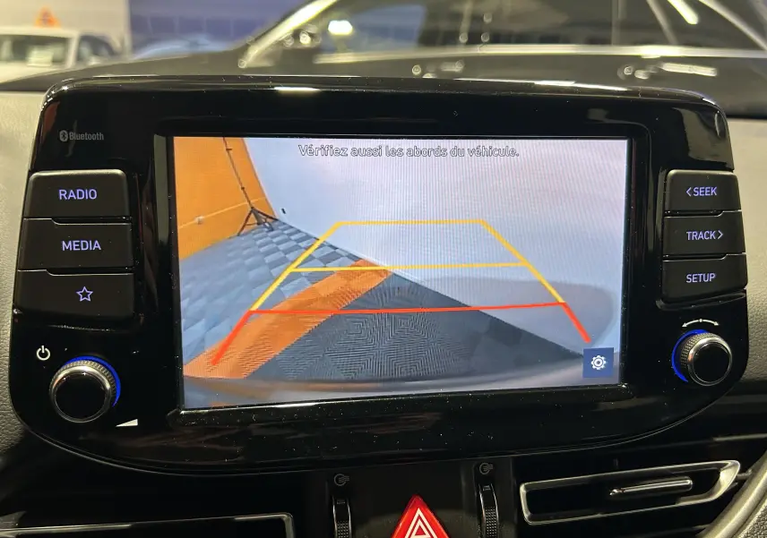 Écran de caméra de recul dans une Hyundai i30 SW 2022, affichant les lignes de guidage en intérieur de garage.