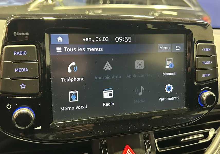 Gros plan sur l'écran tactile central noir de la Hyundai i30 SW 2022 avec menus radio, téléphone et paramètres visibles.