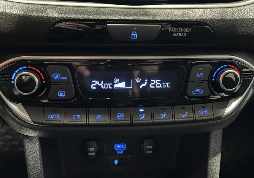 Gros plan sur la console centrale de la Hyundai i30 SW 2022, affichant la climatisation bi-zone et les commandes rétroéclairées.