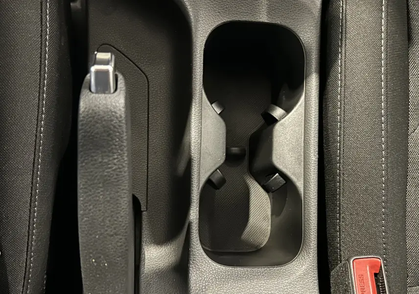 Gros plan sur le frein à main et les porte-gobelets centraux, avec sellerie tissu gris noir de la Hyundai i30 SW 2022.