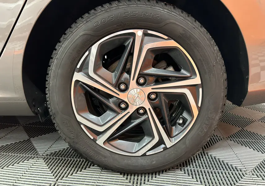 Gros plan sur la roue avant droite d’une Hyundai i30 SW Silky Bronze Metal, jante alliage au design moderne.