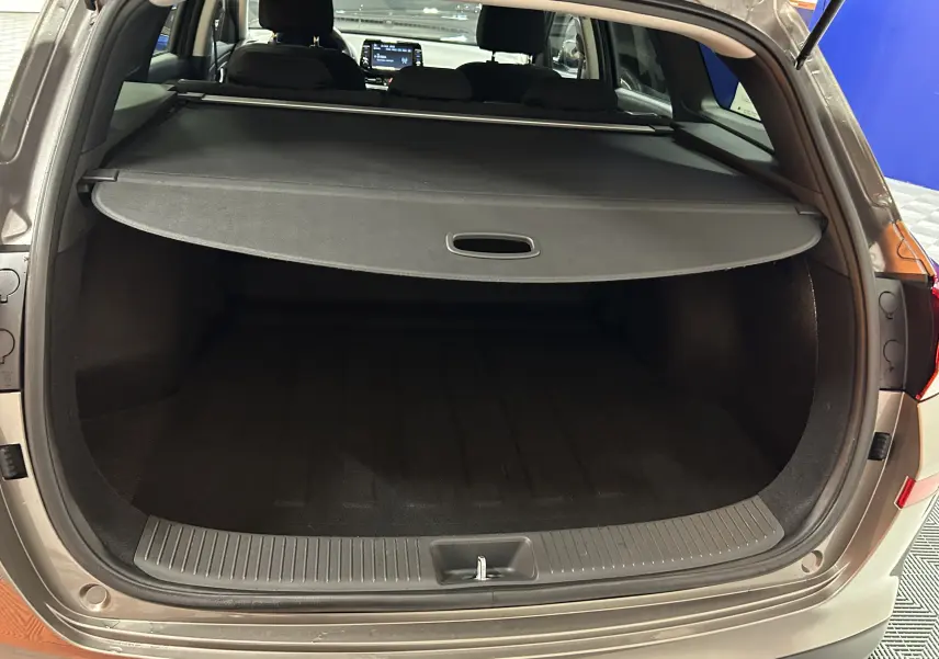 Coffre ouvert vu de l'arrière d'une Hyundai i30 SW 2022 couleur bronze métallique avec cache-bagages déployé.