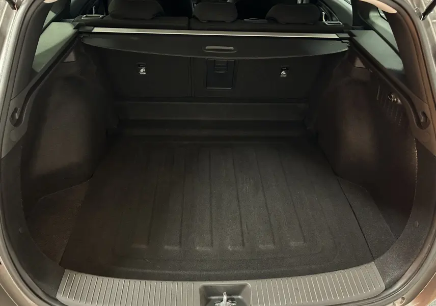 Coffre ouvert vu de l'arrière d'une Hyundai i30 SW 2022 couleur bronze métallique, espace de chargement vide et propre.