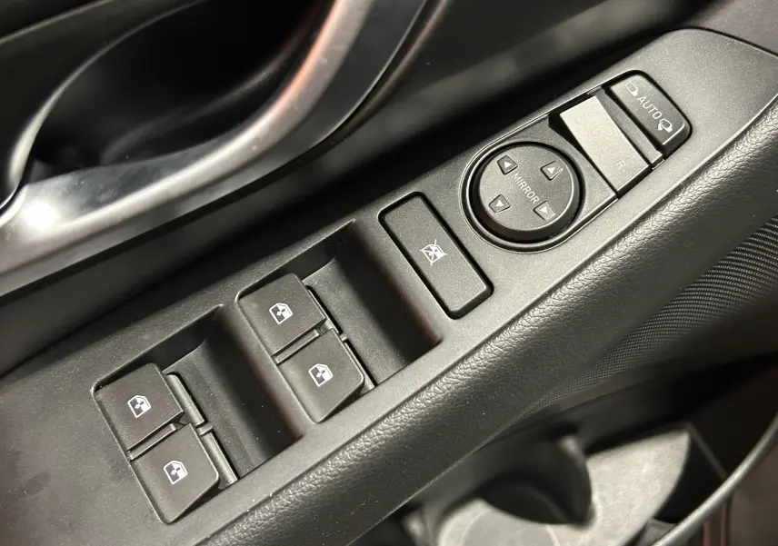 Gros plan sur les commandes de lève-vitres et réglage des rétroviseurs côté conducteur d’une Hyundai i30 SW 2022.