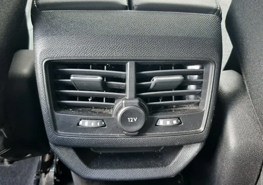 Vue rapprochée des aérateurs arrière noirs et prise 12V au centre du Peugeot 3008 gris Amazonite de 2019.