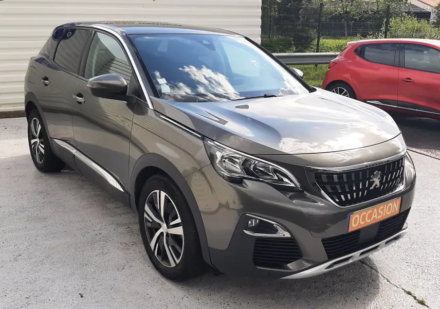 Peugeot 3008 gris amazonite en 3/4 avant droit, avec jantes alliage et calandre distinctive, stationné en extérieur.