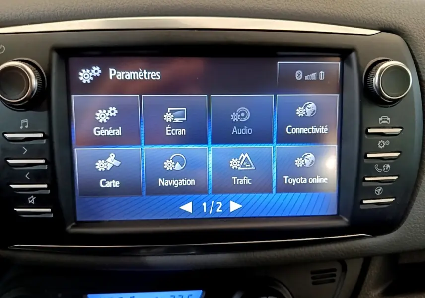 Écran tactile central de la Toyota Yaris 2019 blanc, affichant le menu des paramètres de navigation et connectivité.