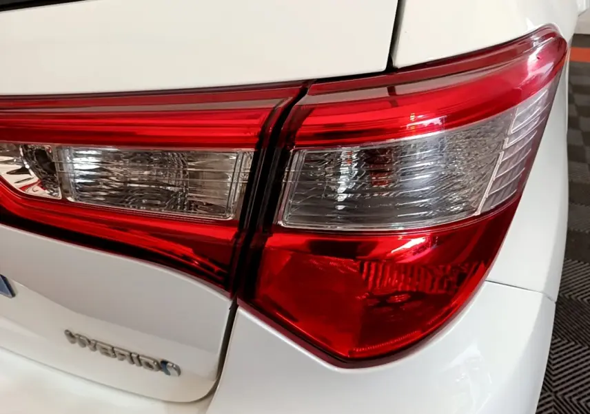 Gros plan sur le feu arrière droit rouge et blanc d’une Toyota Yaris blanche hybride 2019.