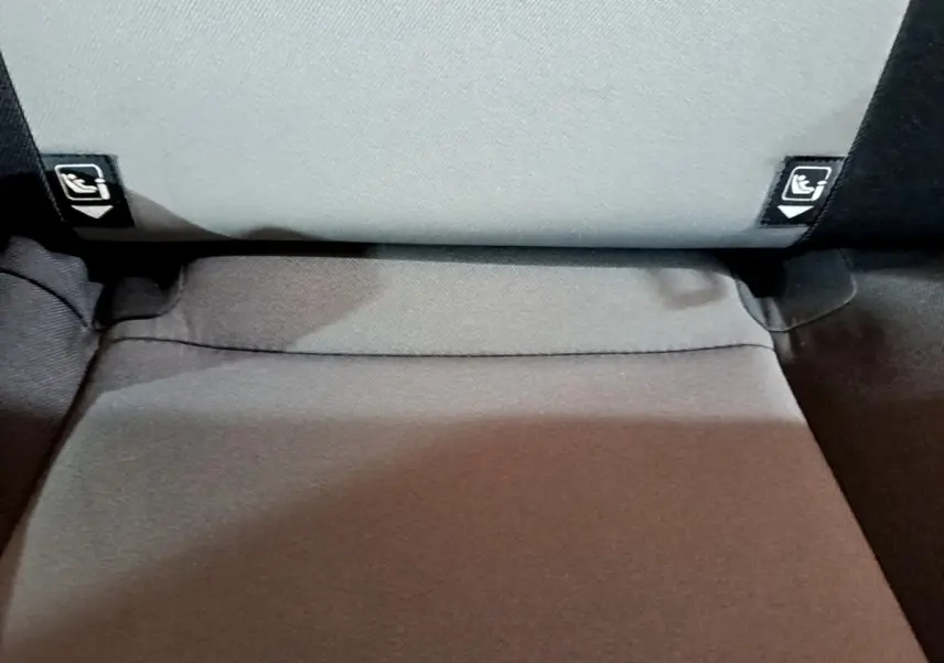 Détail de la banquette arrière grise avec étiquettes Isofix visibles sur une Toyota Yaris blanche hybride 2019.
