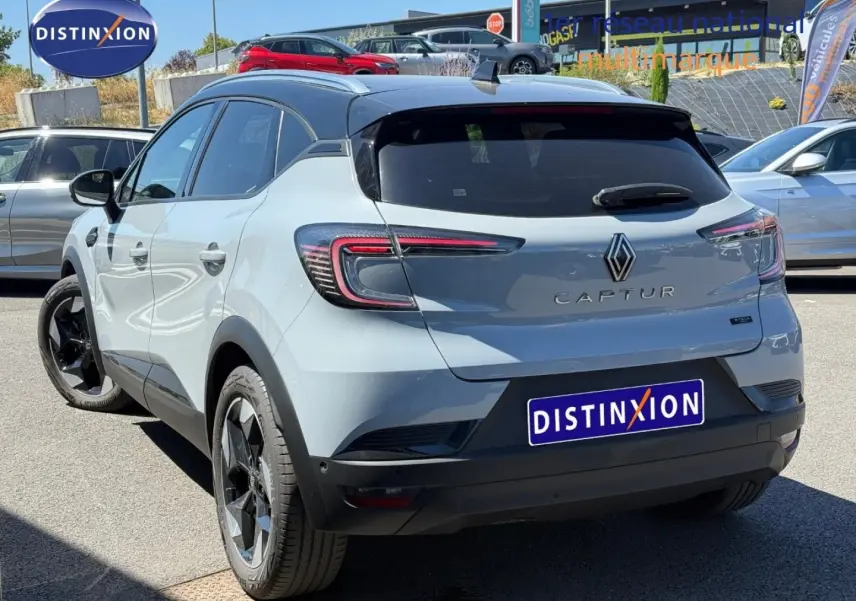 Vue 3/4 arrière droite du Renault Captur 2025 gris Rafale métallisé avec toit noir et jantes noires.