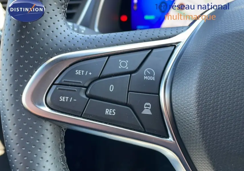 Gros plan sur les commandes de régulateur de vitesse au volant perforé d’une Renault Symbioz noire étoile métal.