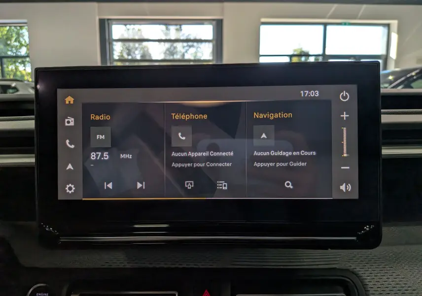 Écran tactile central du Citroën C3 Aircross Hybride 2026 affichant radio, téléphone et navigation, intérieur noir.