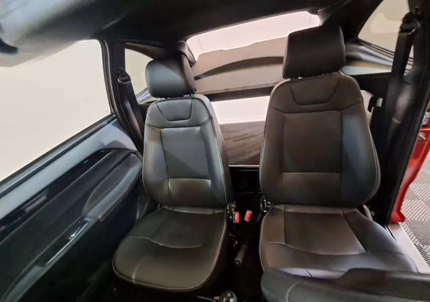 Vue intérieure frontale des sièges avant en cuir noir de l'AIXAM AMBITION 2025 rouge, version City Coupe Sport.
