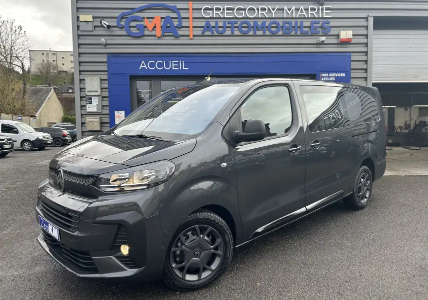 Vue 3/4 avant droit du Citroën Jumpy Cabine Approfondie gris titane métal stationné devant un garage Gregory Marie Automobiles.