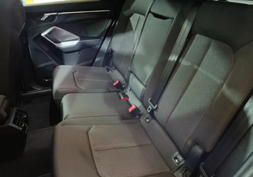 Vue intérieure côté droit des sièges arrière gris foncé de l'Audi Q3 Sportback avec ceintures et appuie-têtes visibles.