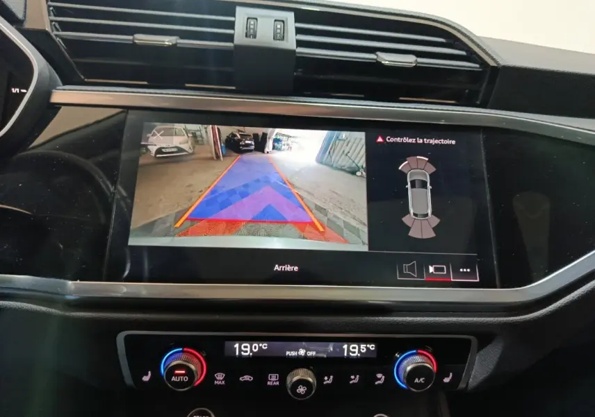Écran tactile intérieur de l'Audi Q3 Sportback 45 TFSI e 2021 montrant l'aide au stationnement arrière avec guidage couleur.