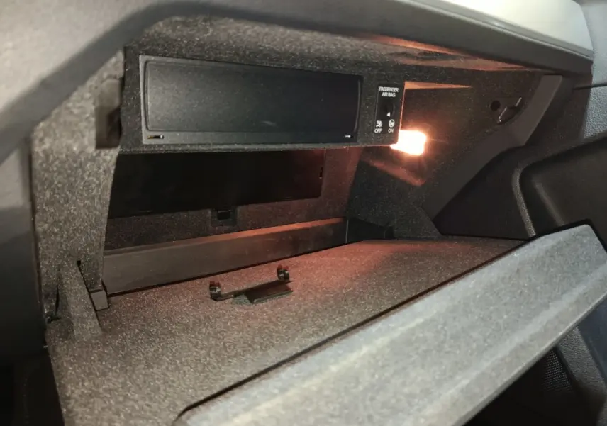 Intérieur de la boîte à gants ouverte de l'Audi Q3 Sportback gris foncé, avec éclairage intérieur activé.
