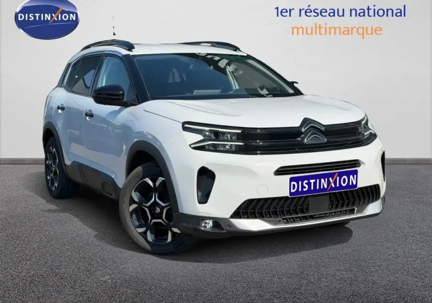 Vue 3/4 avant droite du Citroën C5 Aircross blanc Okénite avec jantes alu et barres de toit noires.