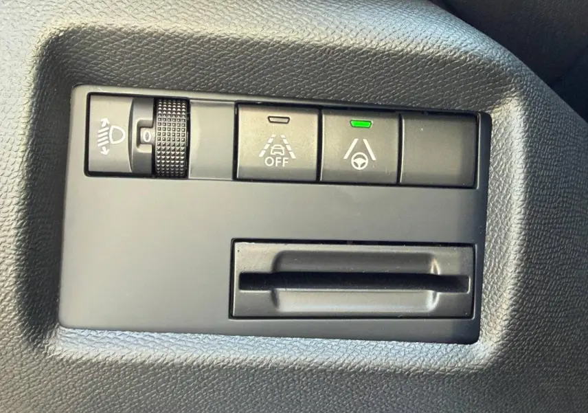 Gros plan sur les commandes d'assistance à la conduite du Citroën C5 Aircross, tableau de bord noir texturé.