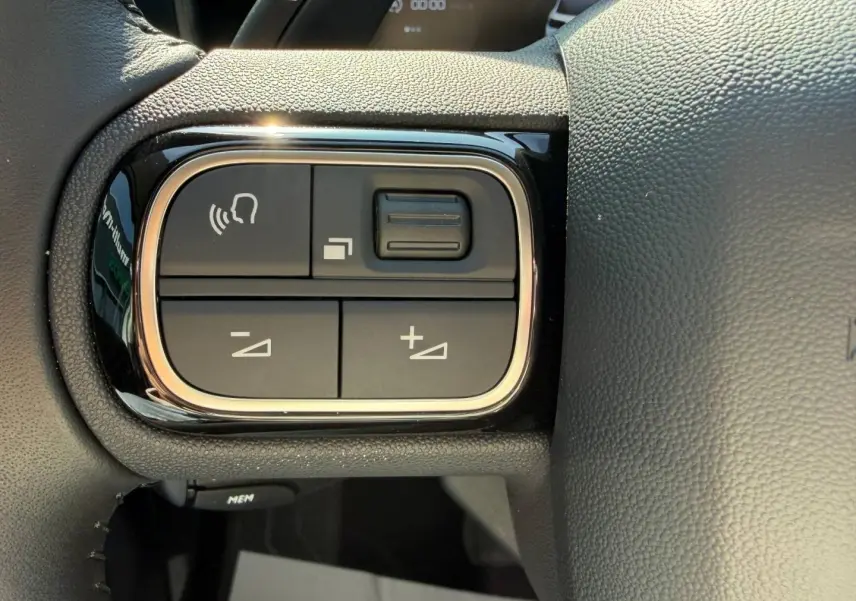 Gros plan sur les commandes vocales et volume au volant cuir noir du Citroën C5 Aircross 2025.