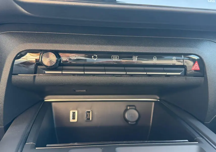 Gros plan sur la console centrale noire du Citroën C5 Aircross 2025 avec boutons de commande et ports USB visibles.