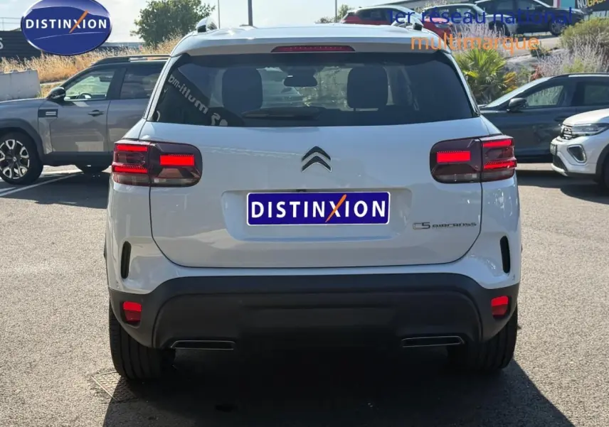 Vue arrière d'un Citroën C5 Aircross blanc Okénite avec feux LED et barres de toit visibles en extérieur.