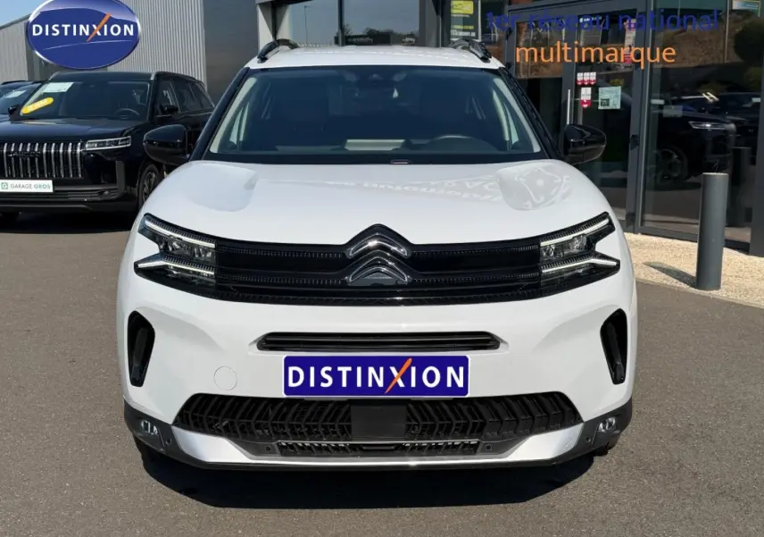 Vue de face du Citroën C5 Aircross blanc Okénite avec calandre noire et barres de toit visibles.