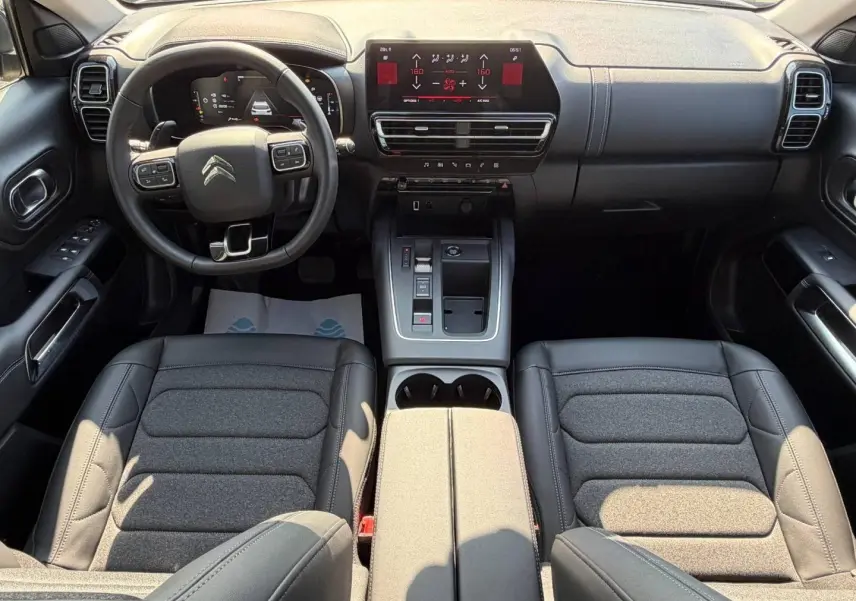 Vue intérieure avant du Citroën C5 Aircross 2025, tableau de bord et volant cuir multifonction noir.