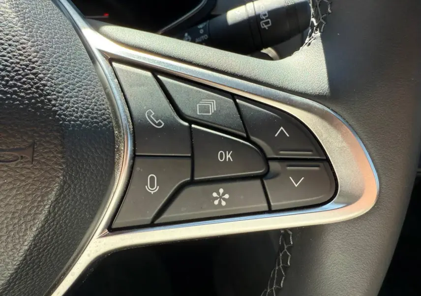 Gros plan sur les commandes multifonctions à droite du volant du Renault Captur 1.6 E-Tech gris Rafale.