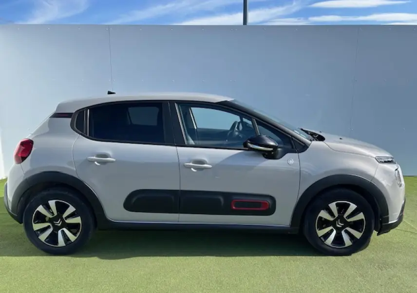 Profil côté droit d'une Citroën C3 1.2 PureTech 83 S&S C-Series sable métal avec protections latérales noires et accents rouges.
