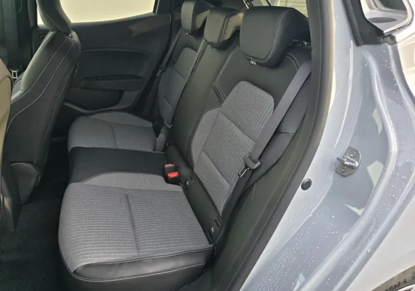 Vue intérieure côté droit sur la banquette arrière gris mélangé d'une Renault Clio V Gris Rafale Métal avec porte ouverte.