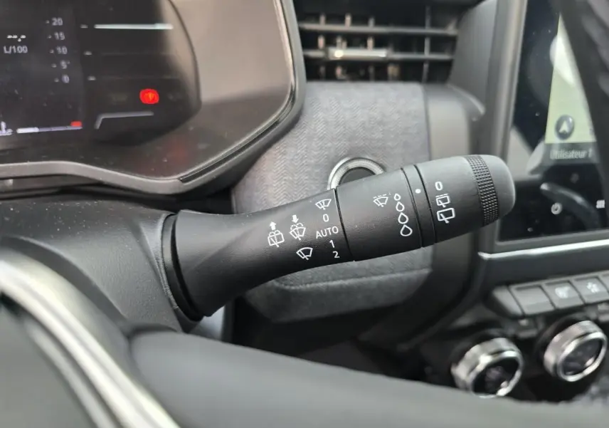 Gros plan sur la commande des essuie-glaces à gauche du volant dans l’habitacle gris mélangé de la Renault Clio V 2025.