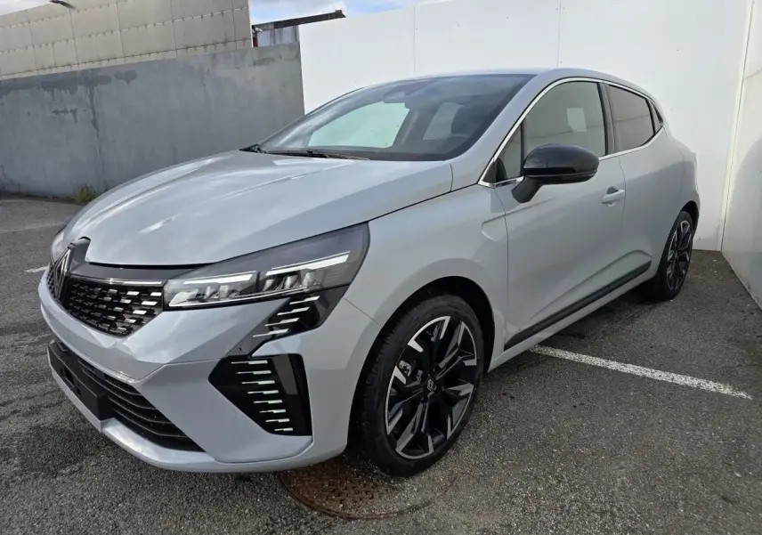 Renault Clio 2025 gris Rafale métal vue 3/4 avant droit, jantes alliage noires et détails chromés visibles.