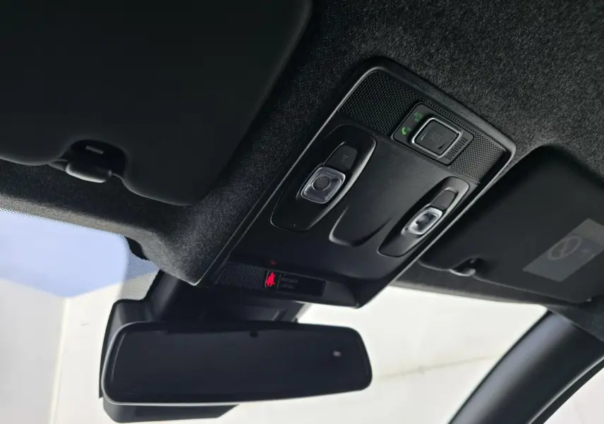 Vue intérieure du plafonnier et du rétroviseur intérieur de la Renault Clio V gris Rafale, avec commandes d’éclairage et SOS.